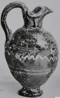 Jug with a loop handle, trefoil mouth and white zigzag and horizontal bands on the body, shown on a plain background
