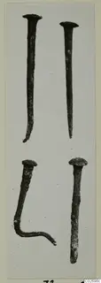 Four corroded nails with flat heads, one bent at the tip and one bent into an L-shape, from Tomb 16 at Marion