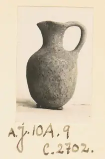 Juglet with a rounded body and single loop handle, photographed on an album page from Ayios Iakovos