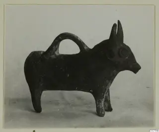 Small dark pottery vessel shaped as a standing bull, with a loop handle over its back, from Ayios Iakovos