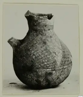 White Painted IV-V pottery vessel with a flaring, broken rim and a small lug on one side