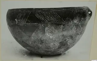 Pottery Red Polished II bowl from Lapithos with incised chevron bands and a small pierced lug