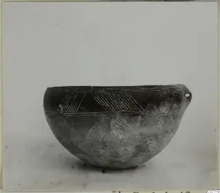Red Polished III bowl with incised chevron bands and a small pierced lug on the rim