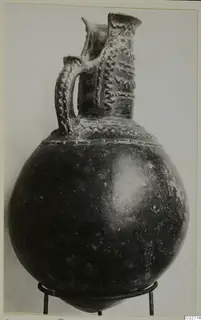 Pottery jug with a strap handle and applied wavy and dotted bands, from the Vrysi tou Barba tombs at Lapithos