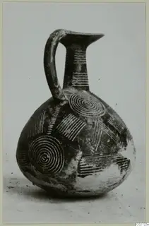 Pottery Red Polished II jug with a high strap handle and concentric circle decoration