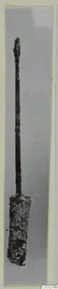 Corroded bronze toilet-requisite with a long slender shaft, pointed tip and broad flattened end