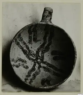 White Painted IV-V bowl from Ayios Iakovos, with a dark wavy painted design on a pale surface