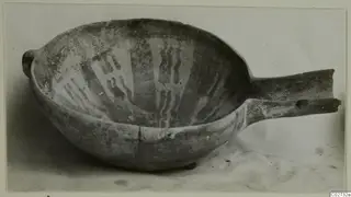 Red-on-Black bowl from Ayios Iakovos with a long horizontal handle and pale painted wavy bands inside
