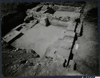 Excavated stone structure at Soli, with low rubble walls, a paved floor and stone blocks in a trench
