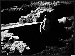 Finds in situ at Cholades, Soli: a narrow-necked vessel standing among excavated stone walls.