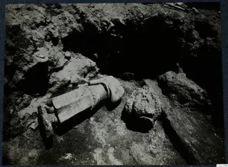 Carved stone sculpture fragments lying in the excavation at Soli, Room XXXIV, with a separate head beside the body