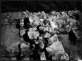 Sculpted head lying half-buried among stones and rubble at Cholades, Soli