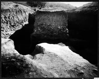 Soil profile in the excavation at Mersinaki: a tall earth section with stones, beside a deep trench