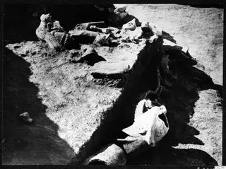 Accumulation of broken stone statue fragments lying on an earth ledge in excavated ground at Mersinaki.
