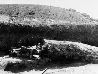 Excavated trench at Mersinaki with pottery vessels and sherds lying in the soil at the left