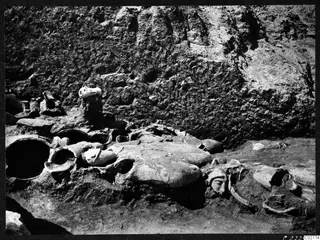 Statue accumulation in I 20-21 at Mersinaki: broken stone sculptures, including a face, lying together in excavated ground.