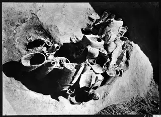 Pit H 14-15 with broken pottery vessels and sherds lying in situ in the excavated ground, seen from above