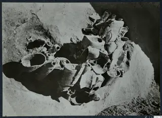 Pit H 14-15 with broken vessels and sherds lying in situ in sandy soil