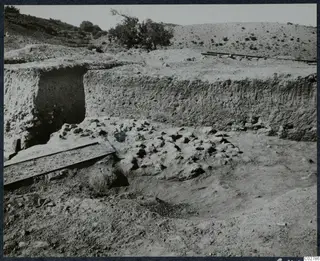 Soil section and excavated trench at Mersinaki, with scattered stones and a rail track in the foreground