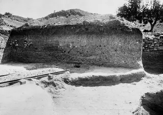 Soil section at Mersinaki with a rail track running across the excavation floor in front of it.