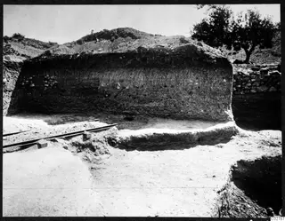 Vertical soil section in an excavation trench at Mersinaki, with rails running across the trench floor in front
