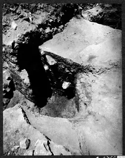 Soil profile in excavation pit at Mersinaki, with a cut earth face containing embedded stones.