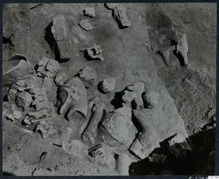 Statue fragments and heads lying in excavated soil at Mersinaki, heads of different sizes
