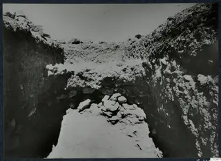 Trench 1 at Mersinaki, with a heap of stones at the far end of a narrow excavated trench