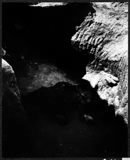 Objects found in situ in pit E-F 10-11 at Mersinaki, lying in a dark excavation pit beside a soil face.