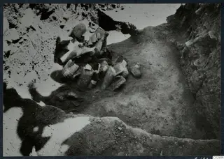 Field photograph of objects found in situ in pit G-H 14 at Mersinaki, a cluster of broken pale objects in excavated soil