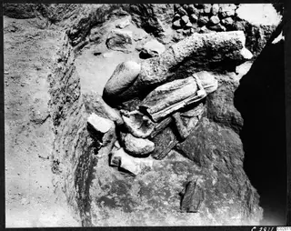 Carved stone fragments lying in situ at Mersinaki in Pit II, among rubble in an excavated pit