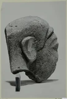 Limestone Cypro-Greek I head statuette from Kition, seen from the side with its ear modelled in relief.