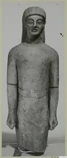 Standing limestone statue from Kition, figure with arms straight at its sides and fists clenched