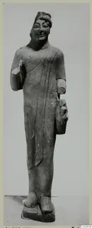 Limestone statue of a standing figure in a long draped garment, from Kition, with broken arms.