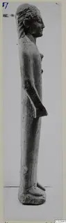 Limestone statue of a standing figure, seen in profile facing right.