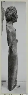 Limestone statue of a standing figure seen in profile, facing right