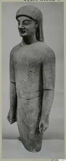 Limestone statue of a standing figure with a cap-like headdress and arms at its sides, from Kition
