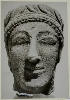 Limestone head fragment from Kition, face with heavy eyelids, broken nose and banded headdress