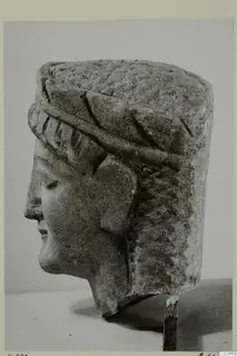 Limestone head from Kition, shown in profile facing left, with a tall cylindrical headdress.