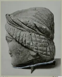 Limestone head of a statuette from Kition, wearing a wrapped headdress with ribbed bands