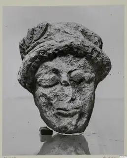 Limestone head of a statuette from Kition, wearing a close-fitting cap, with a worn and damaged face