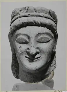 Limestone head from Kition with a broad hair band across the forehead, almond-shaped eyes and a slight smile
