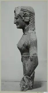 Limestone statue of a female figure in side profile from Kition, arms at her sides, with a broken base