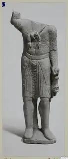 Headless limestone statuette of a standing figure in a belted, pleated garment, from Kition