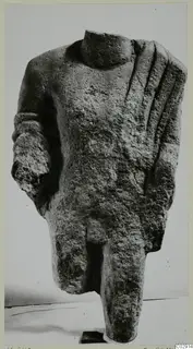Headless limestone statue torso from Kition, with one arm partly preserved and grooved drapery folds