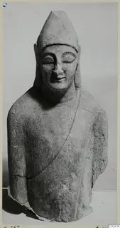 Limestone sculpture of a figure with a tall pointed headdress and closed eyes, from Kition