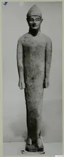 Limestone statue from Kition of a standing figure wearing a pointed cap