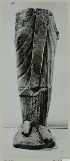 Limestone statue fragment from Kition: lower draped body and feet on a base