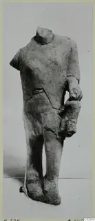 Headless limestone statue of a standing figure with one arm bent across the body, from Kition