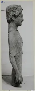 Limestone statue of a standing figure seen in profile, with carved hair and hands clasped at the front of the body